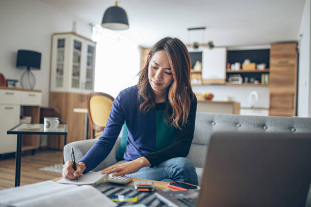 Young japanese woman doing her finances at home