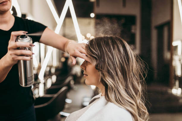 Beautiful brunette woman with long hair at the beauty salon getting a hair blowing. Hair salon styling concept.