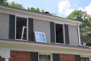 A home with windows removed and replacement windows ready to be installed - an effective way to cut energy costs.