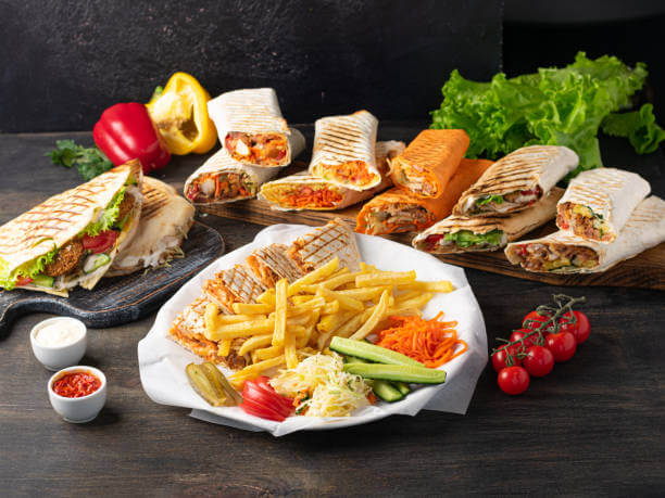 Assorted shawarma on wooden background.