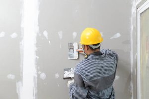 interior decoration construction furniture builtin.Plasterer in working uniform plastering the wall indoors.