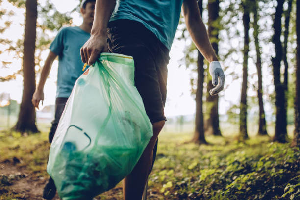 Group of  volunteers with garbage bags cleaning park area