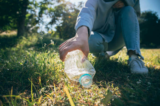 Woman hand holding garbage bottle plastic putting into recycle bag for cleaning