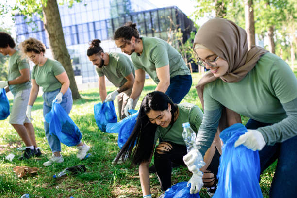 Multiethnic group of volunteers with garbage bags cleaning city park.