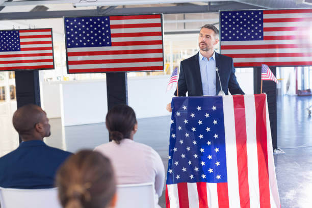 Front view of Male speaker speaking in a business seminar at conference meeting. International diverse corporate business partnership concept