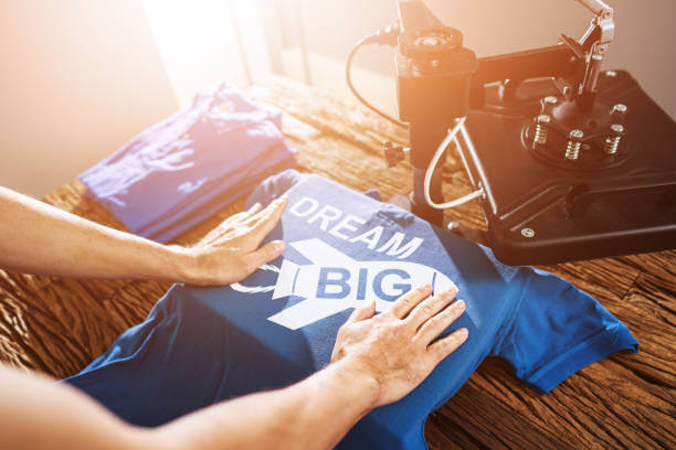 Man Printing On T Shirt In Workshop