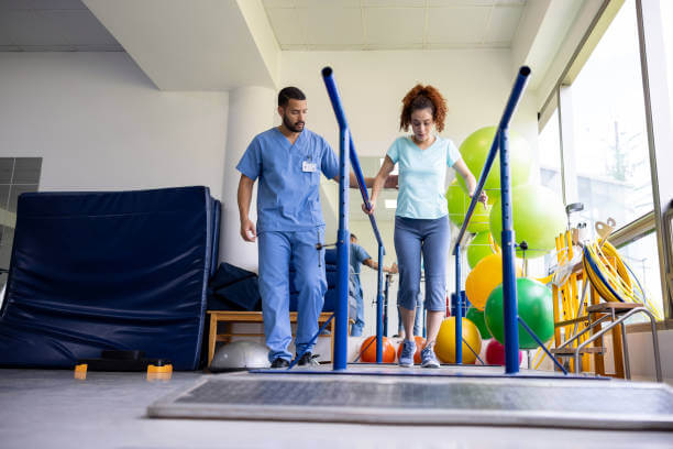 Woman in physical therapy walking on bars while recovering from an injury - healthcare and medicine concepts