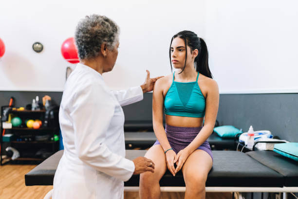 Young woman talking to the physical therapist at a rehabilitation center