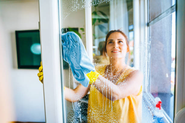 Young woman washing window stock photo