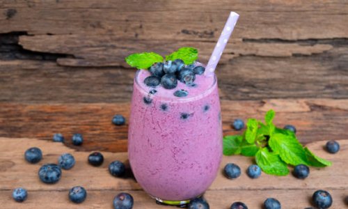 Blueberry  smoothie purple colorful fruit juice milkshake blend beverage healthy high protein the taste yummy In glass drink episode morning on a wooden background.