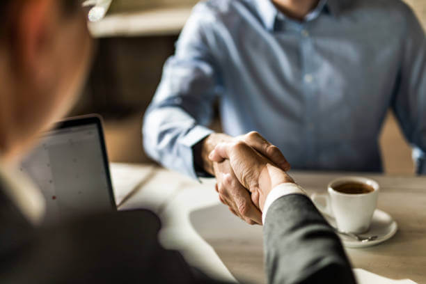 Close up of two unrecognizable men shaking hands on a meeting in the office.